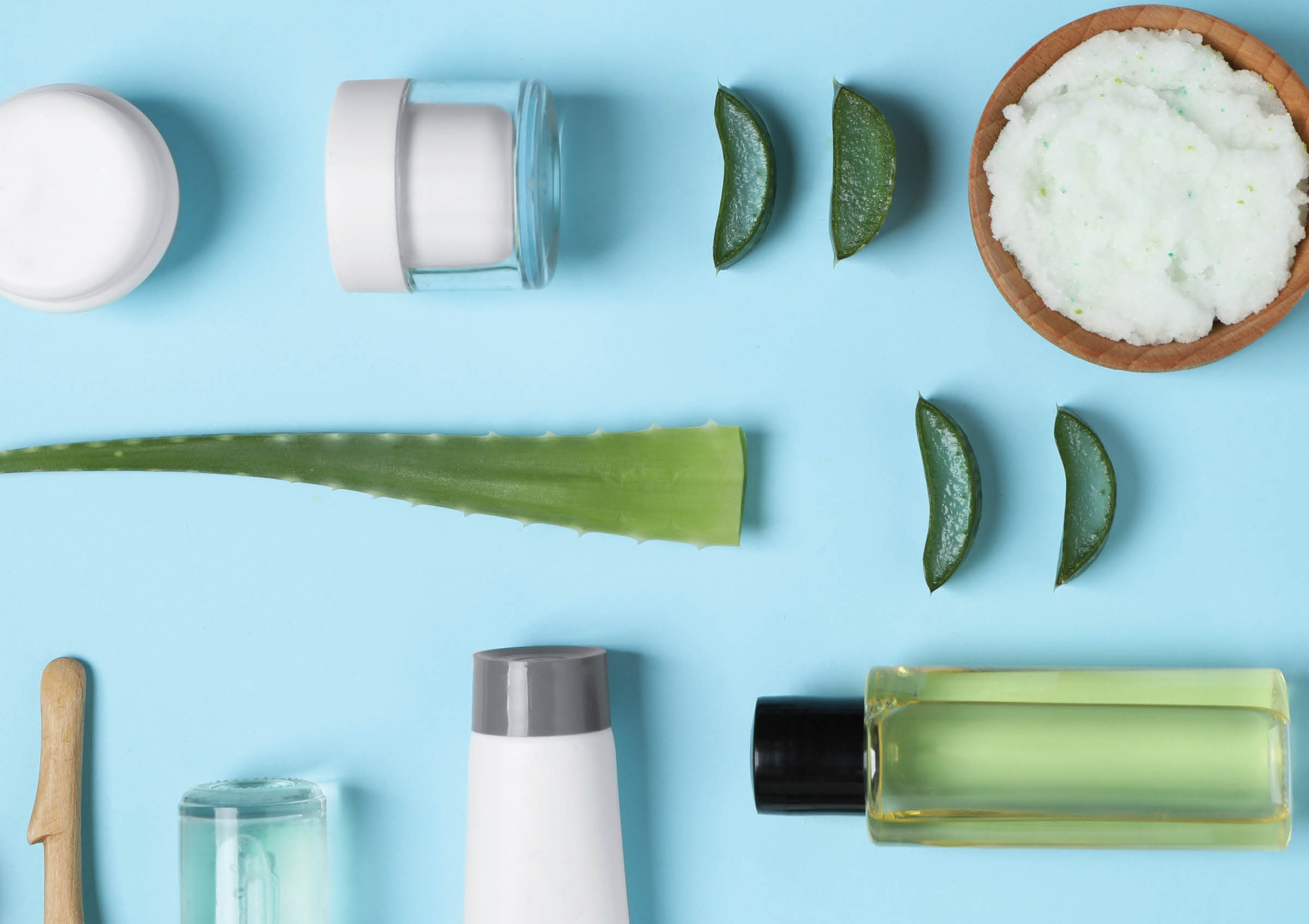 Flat lay composition with aloe vera and cosmetic products on light blue background  Space for text