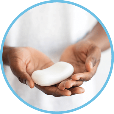 African man holding a bar of white soap in his hands. Healthcare and antivirus protection concept