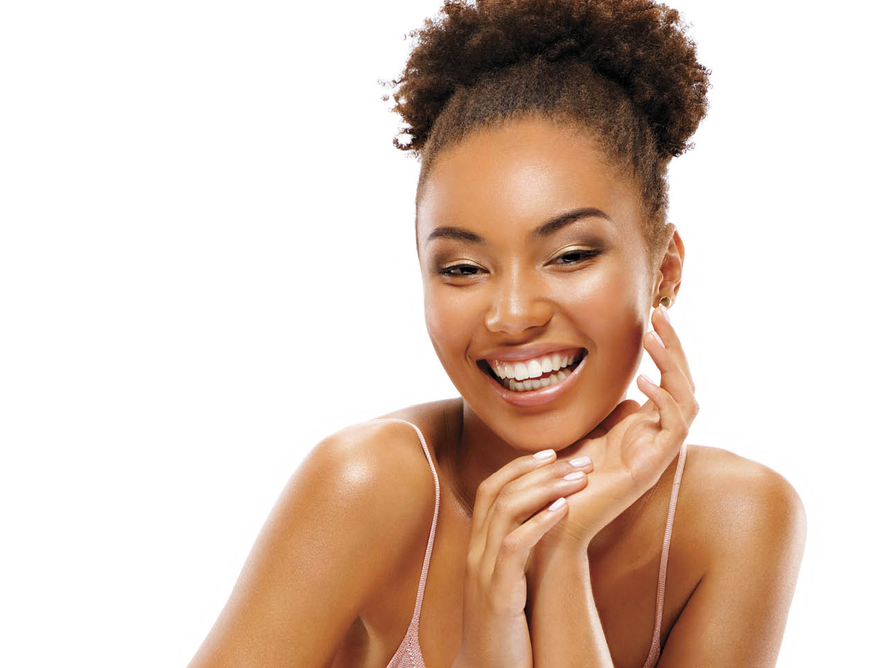 Young girl touching her healthy skin. Photo of smiling african american girl on white background. Youth and skin care concept