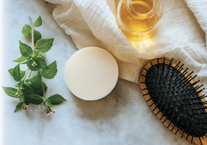 Eco-Friendly Solid Shampoo bar hair care product with Argan Oil laying on a marble background.
