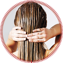 Woman applying hair conditioner. Isolated on white.