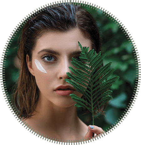 Beautiful young woman with perfect skin and natural make up posing front of plant tropical green leaves background with fern. Teen model with wet hair care of her face and body. SPA, wellness