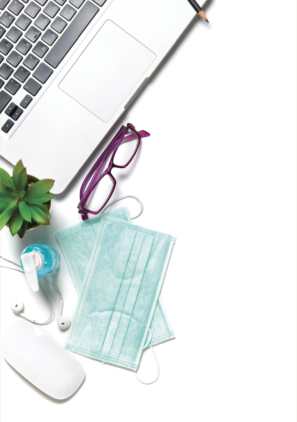 White office desk table with surgical face mask and sanitizer bottle or alcohol gel with laptop isolated on white background, work from home and covid-19 concept and new normal