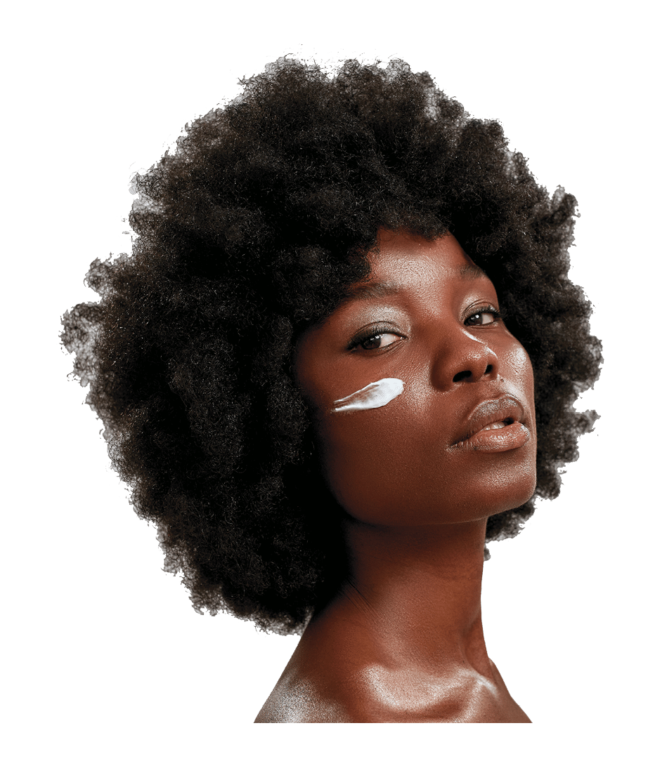 Beauty portrait of young naked african american woman with afro hair looking at camera while posing with cream applied on her face isolated over gray background. Skin care concept