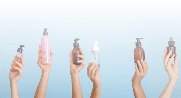 Many female hands with different cosmetic products on color background