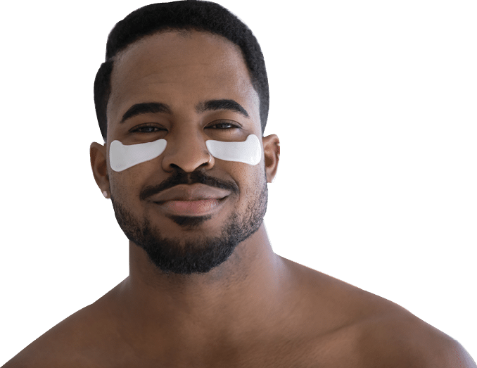 Head shot portrait of handsome African shirtless man with applied moisturizing under-eye anti-wrinkle patches pose look at camera. Facial beauty skincare, removing bags and circles treatment concept