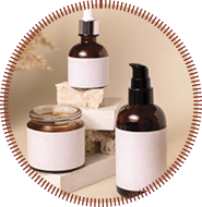 Cosmetic bottles on beige stones near dry pampas grass on light beige close up. Labels Mockup. Skincare beauty product packages. Natural cosmetics, minimal boho composition