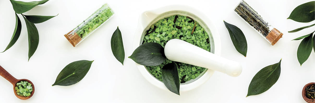Make cosmetics with tea tree essential oil. Fresh tea tree leaves, mortar and pestel, cosmetics on white background top view border copy space