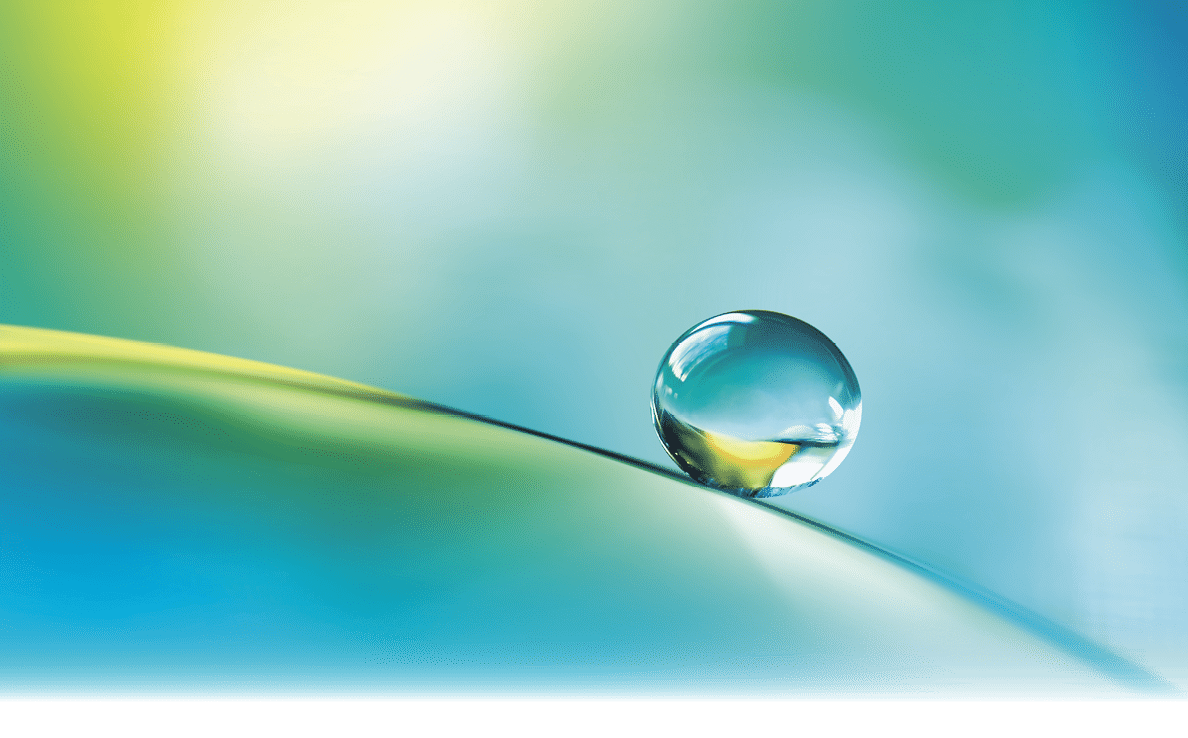 Beautiful clean transparent bright drop of water on smooth surface in blue and yellow colors, macro. Creative image of beauty of environment and nature.