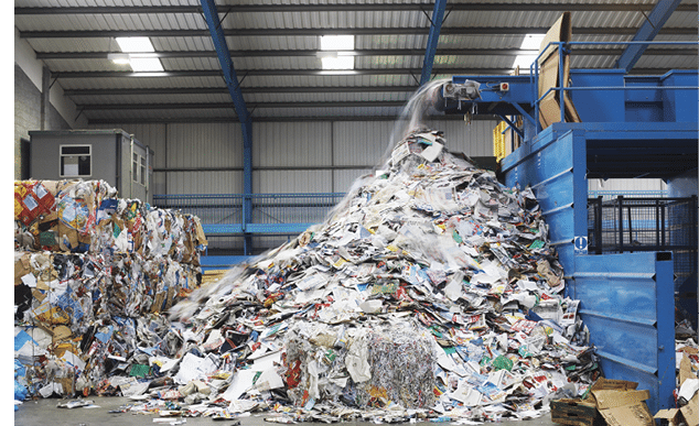 Waste falling on pile from conveyor belt at recycling factory