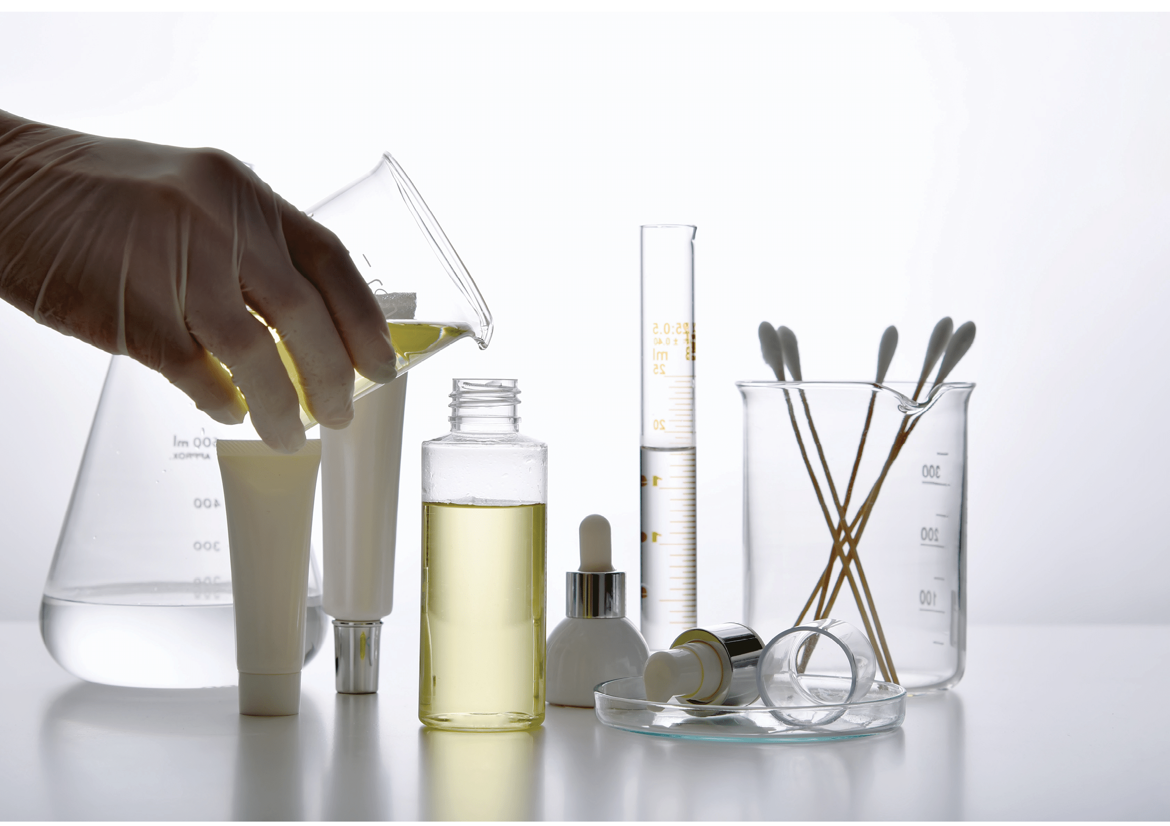 Dermatologist formulating and mixing pharmaceutical skincare, Cosmetic bottle containers and scientific glassware, Research and develop beauty product concept.