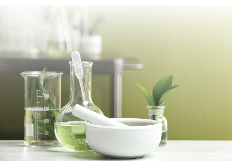 Mortar with pestle and natural ingredients on white table in cosmetic laboratory