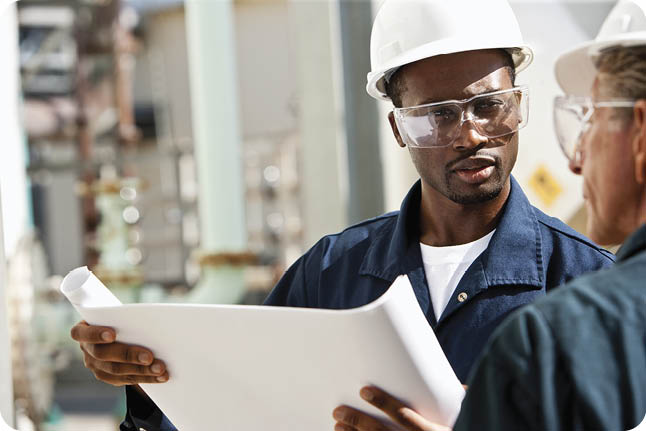 Young man, 20s, looking at plans with senior co-worker