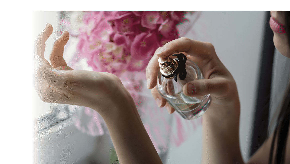 Woman applying perfume on her wrist. Perfume bottle female spray