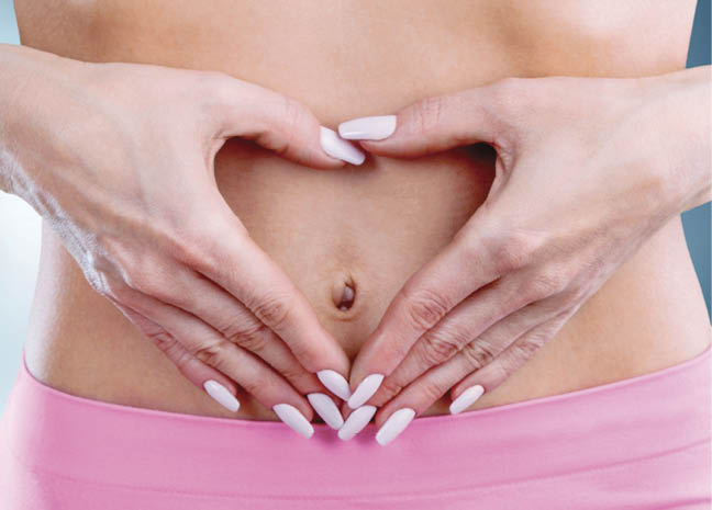 Young beauty woman make a heart from hands on her belly