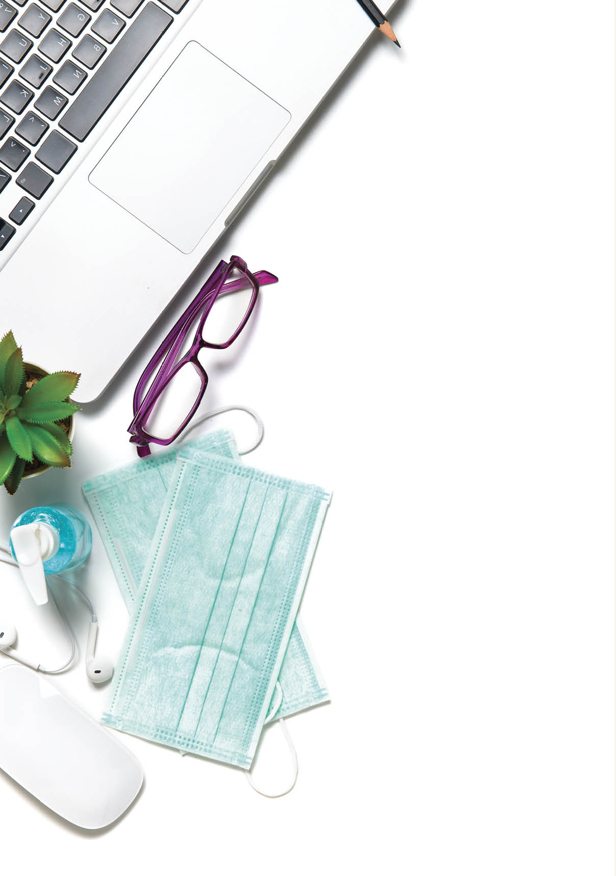 White office desk table with surgical face mask and sanitizer bottle or alcohol gel with laptop isolated on white background, work from home and covid-19 concept and new normal