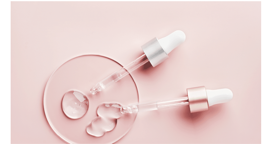 Two pipettes with different samples of gels cosmetic products in petri dish on pink background
