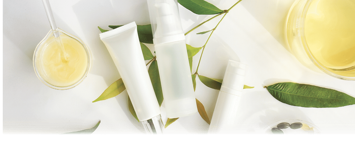 Cosmetic bottle containers with green herbal leaves, Blank label for branding mock-up, Natural beauty product concept.