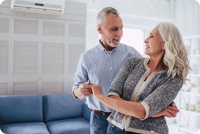 Love lives forever! Senior couple at home. Handsome old man and attractive old woman are enjoying spending time together while dancing.