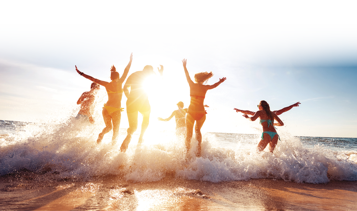 Big group of seven happy friends is having fun and runs at sunset beach to sun light and waves